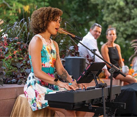 A woman is sitting at a piano, singing into a microphone. AI generated content