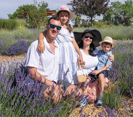 A family of four poses for a picture in a field of lavender. AI generated content