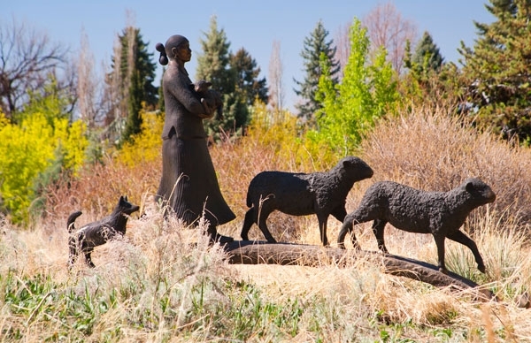 scultupres of person watching over animals