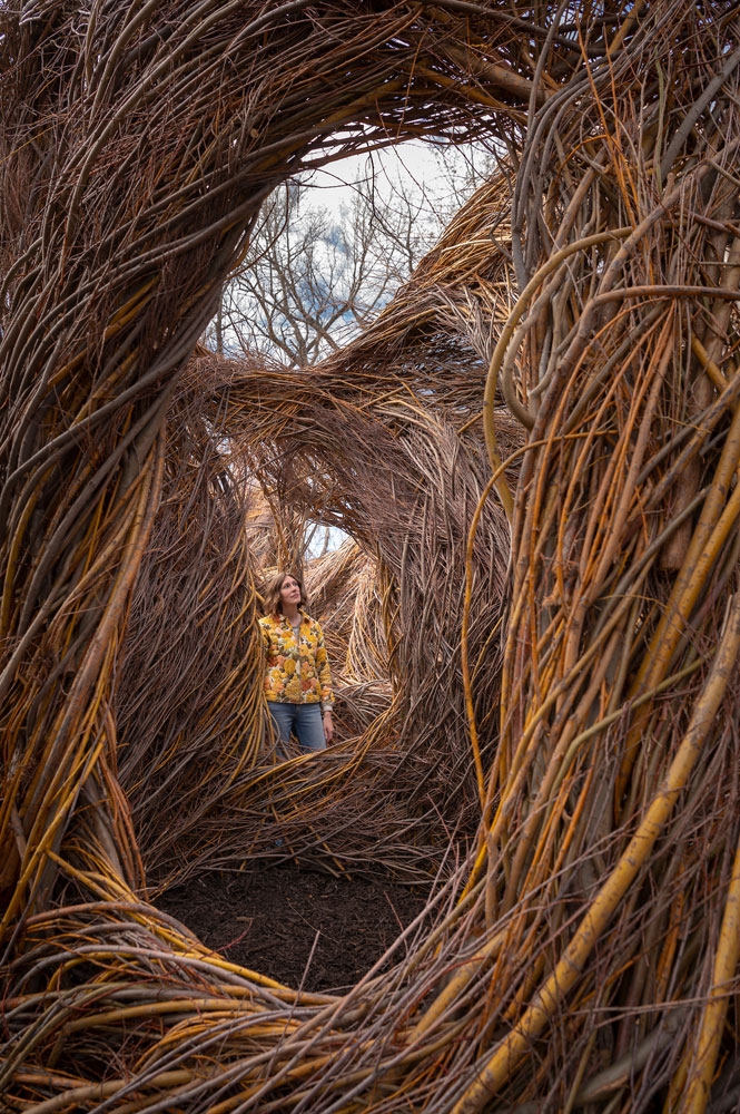 One Fell Swoop (2019), View of woman through holes in sculpture.