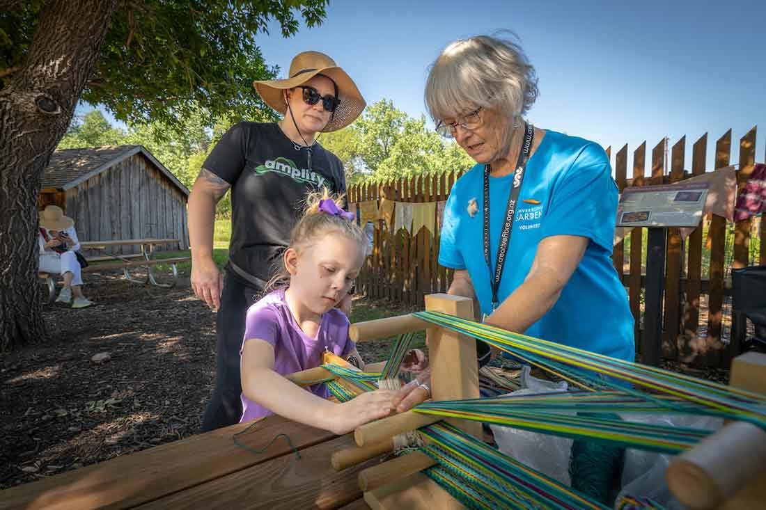 Lavender Festival at Chatfield Farms Two adults and one child weaving at Lavender Festival