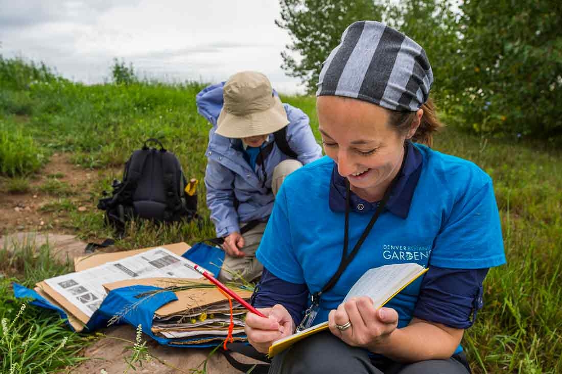 Person documenting plant collection in a notebook