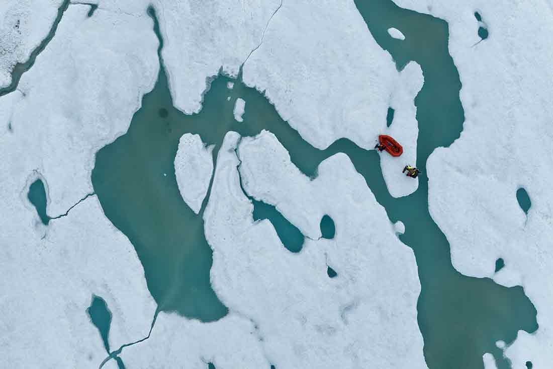 Brian Buma and Alejandra Borunda cross pull their raft between the mainland and the northernmost land in the world, Inuit Qeqertaat (Kaffeklubben Island). Two people cross pull their raft between the mainland and the northernmost land in the world, Inuit Qeqertaat (Kaffeklubben Island).