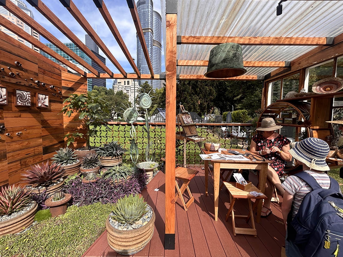 an inviting back porch with plants, an easel and two people