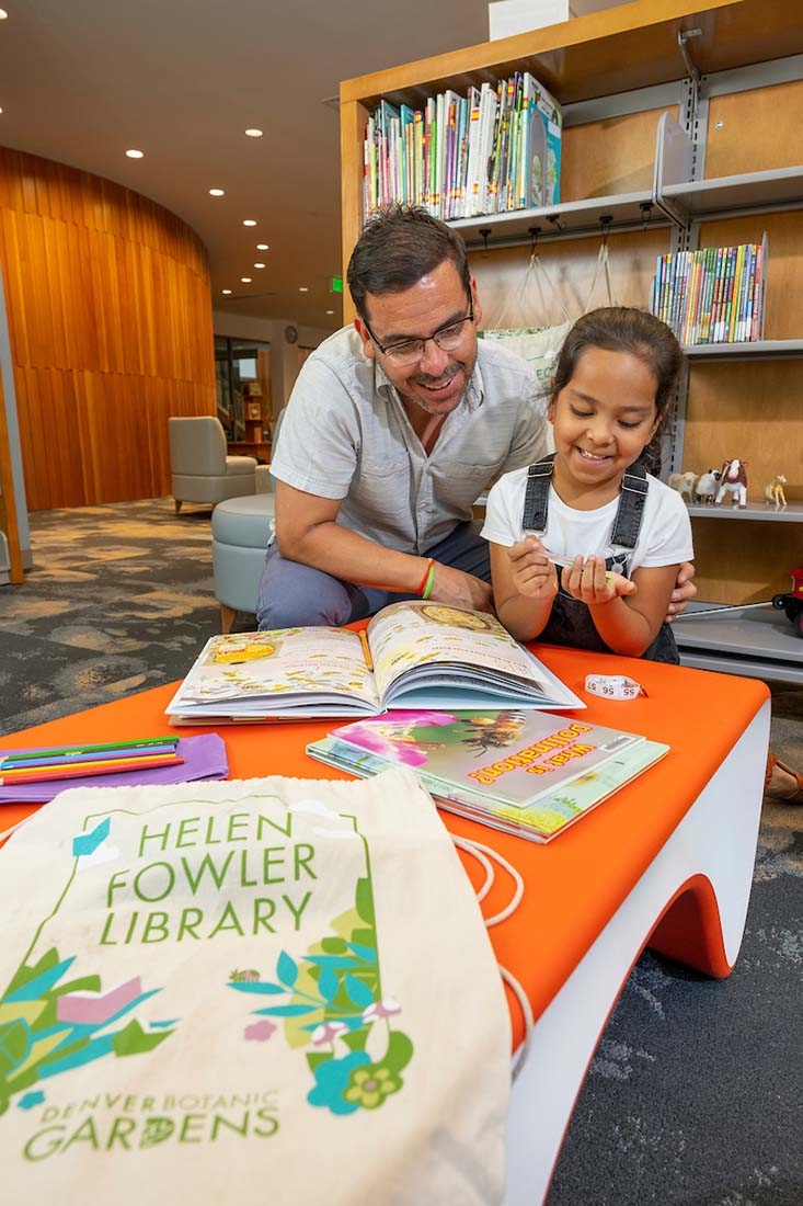 Dad and daughter reading book in library