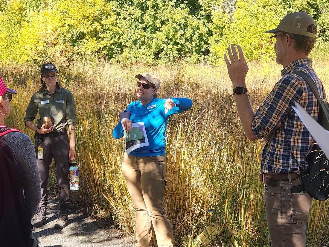 person in front of field of golden grass leading lecture
