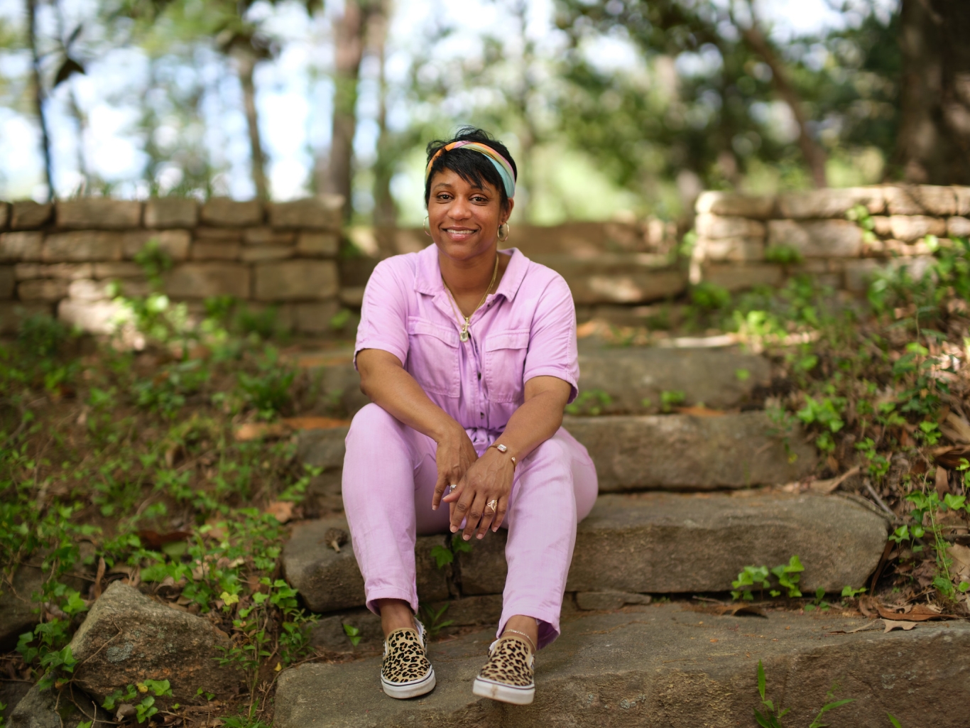 Woman in pink pants suit sitting on stone steps