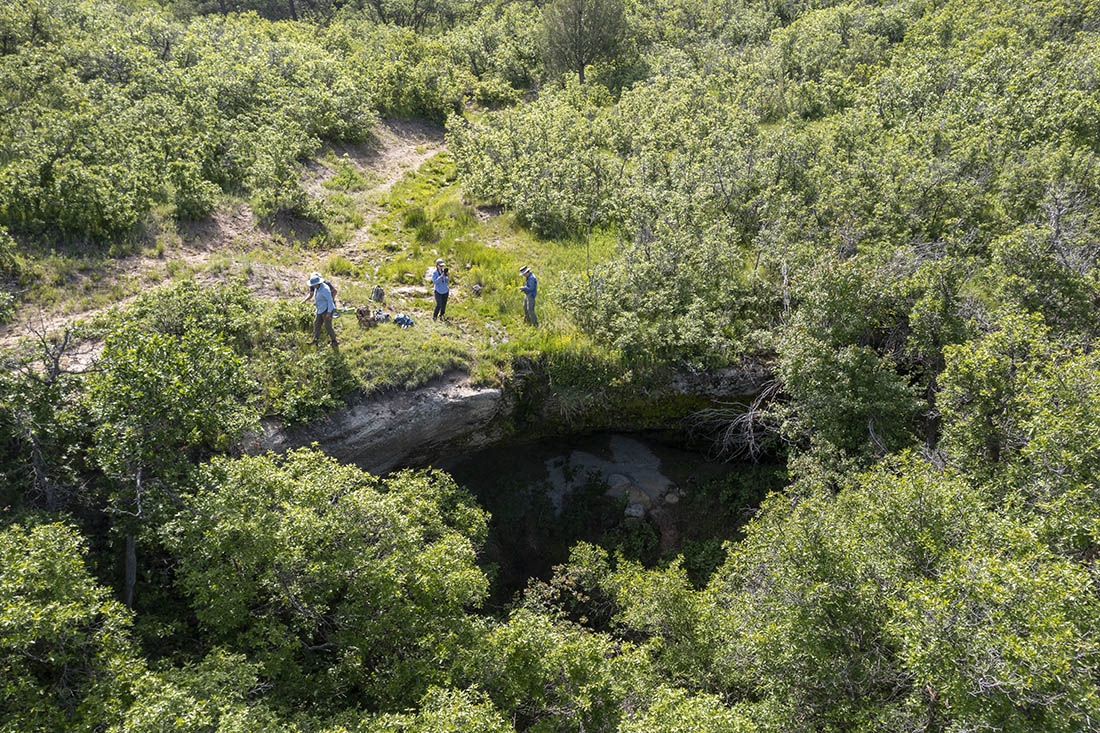 An aerial photo of researchers in wooded area by water