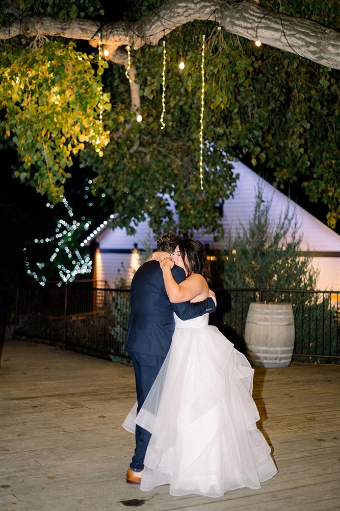 Bride and groom dancing outside at night