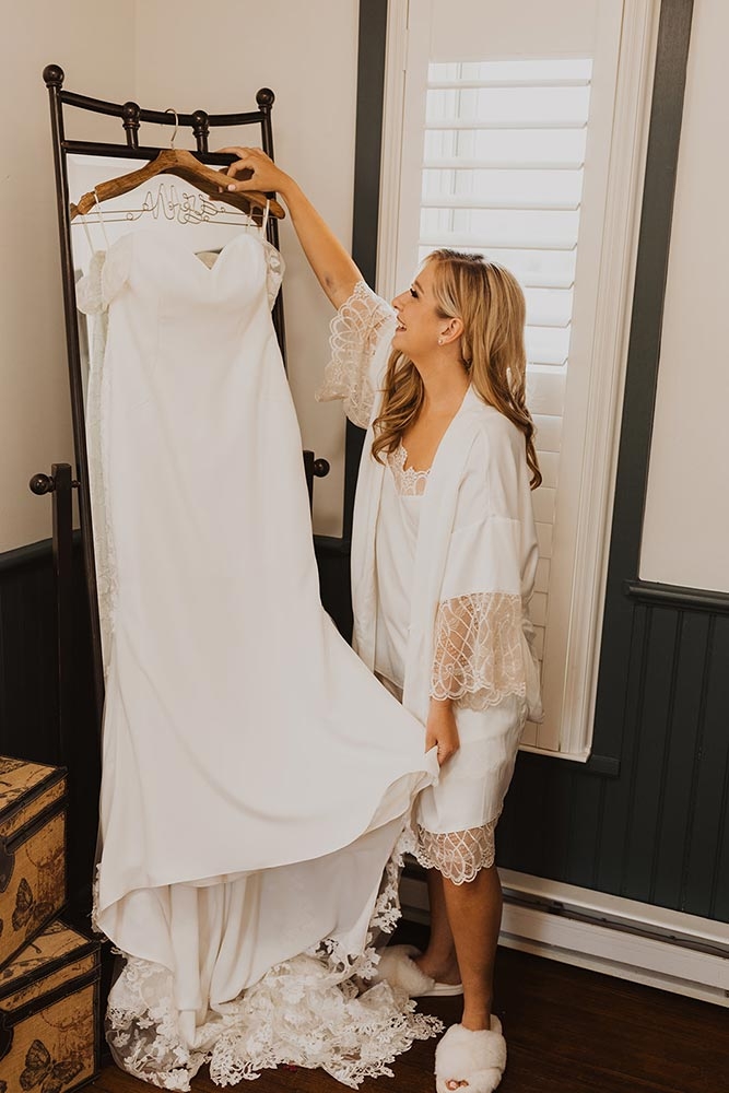 Woman looking at wedding dress she is holding