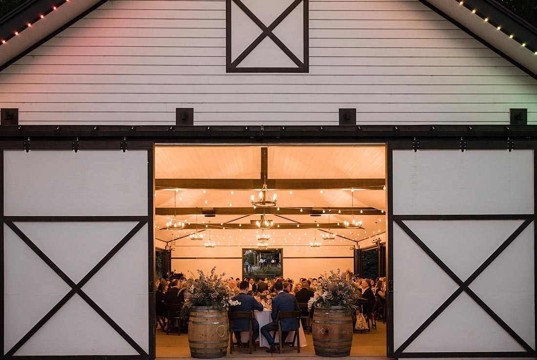 Looking into a stable where a wedding reception is being held in the early evening