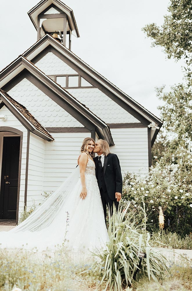 Bride and groom outside standing in front of a schoolhouse