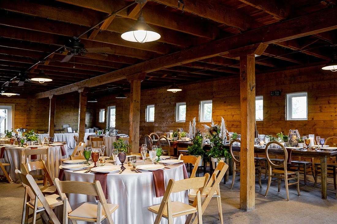 Tables and chairs set up for an inside wedding reception. 