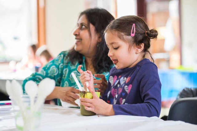Family Programs Adult and child creating a craft together