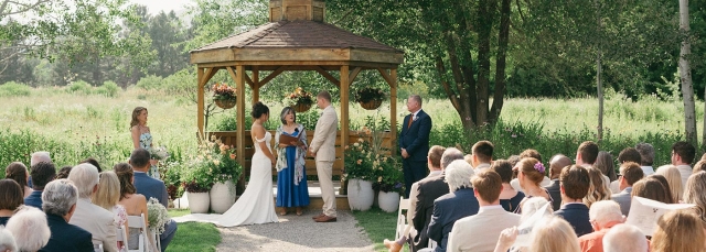 A wedding taking place outside in a gardens