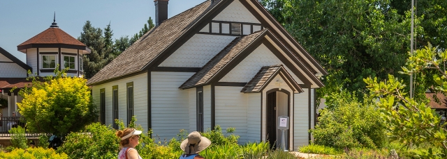 White schoolhouse surrounded by a garden