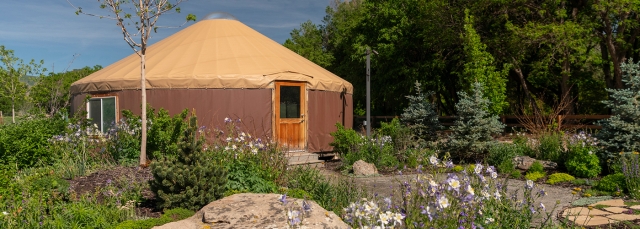 A yurt surrounded by colorful gardens