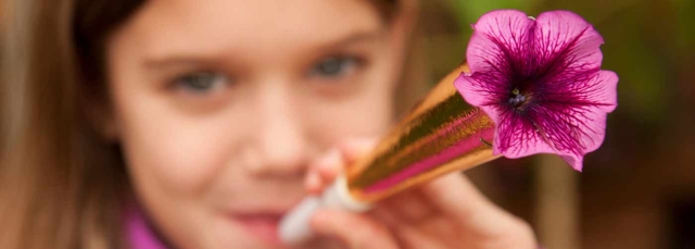 Child with party favor with a pink flower