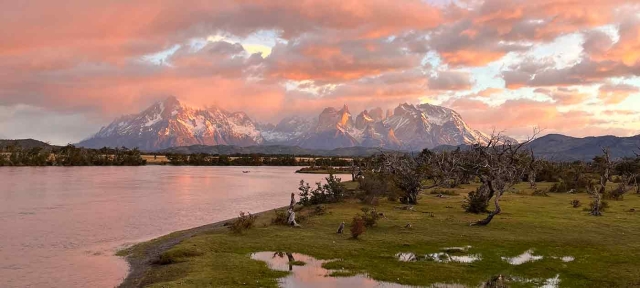 Clouds and a sunset over the mountains with a lake in the foreground